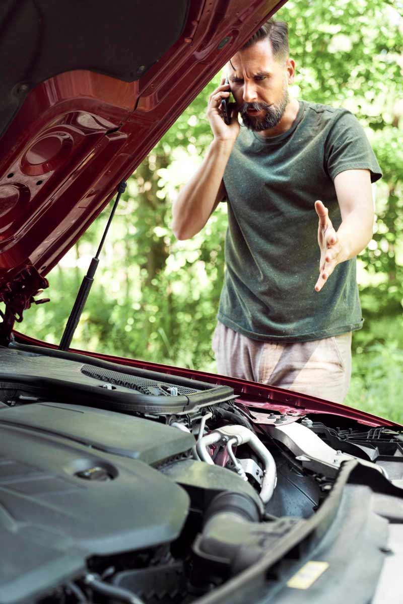 Junger Mann prüft Getriebeschaden bei Schrottauto Ankauf Moers